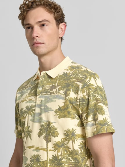 Männermodel trägt Regular Fit Poloshirt mit floralem Allover-Print Modell 'Hawaii' von JACK & JONES Premium aus Reine Baumwolle, Nahaufnahme Oberkörper.