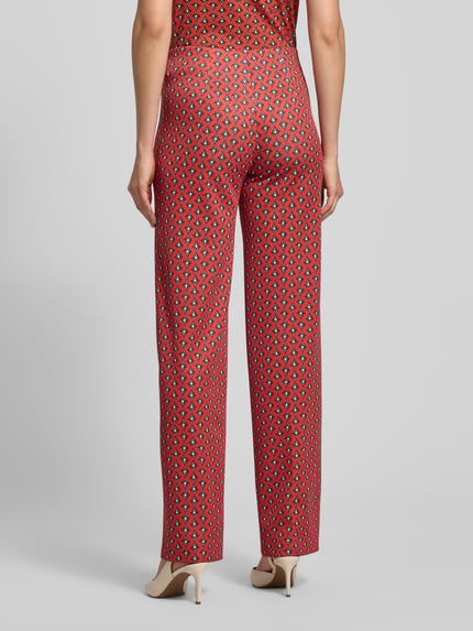 Frauenmodel trägt Hose im Allover-Look mit elastischem Bund von Marc Cain, rot-gemustert, Material-Mix, Regular Fit, Ganzkörperansicht Rückansicht.