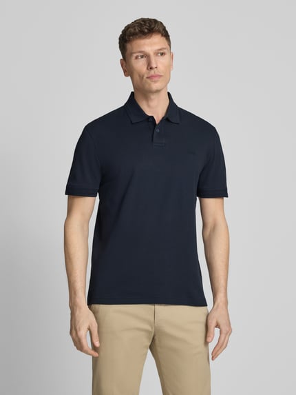 Männermodel trägt Regular Fit Poloshirt aus reiner Baumwolle Modell 'INTERLOCK' von BOSS Orange, Optik: Unifarben, Ganzkörperansicht von vorne.