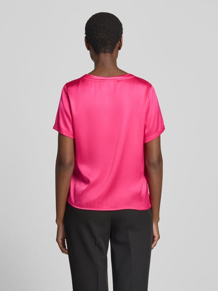 Frauenmodel trägt Blusenshirt aus Satin mit Rundhalsausschnitt von Christian Berg Woman Selection in Pink, glatte Oberfläche, Ganzkörperansicht Rückansicht.