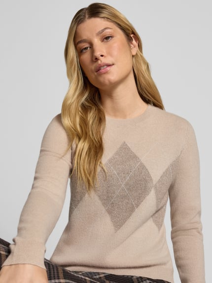 Modelka kobieca ma na sobie Slim Fit Strickpullover aus Kaschmir-Mix mit Rundhalsausschnitt von Christian Berg Woman, kolor beżowy, wzór rombów, krój slim fit, długie rękawy, ściągacze na rękawach i dole, dzianinowa faktura, kaszmirowa mieszanka, widok z przodu na górną część ciała.