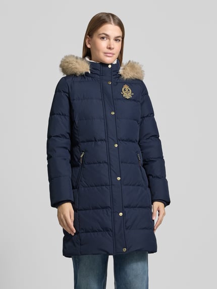 Frauenmodel trägt Steppmantel mit Kapuze von LAUREN RALPH LAUREN in Dunkelblau, Logo-Applikation, goldene Knöpfe, Ganzkörperansicht von vorne.
