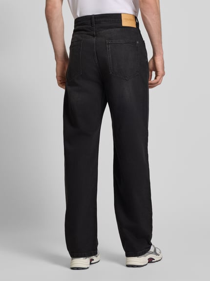 Mężczyznamodel nosi Baggy Jeans in schwarzer Waschung und klassischem 5-Pocket-Design von REVIEW, Mieszanka bawełny i elastanu, krój baggy, efekt sprania, 5 kieszeni, zapięcie na guzik i zamek błyskawiczny, szerokość w rozmiarze 32: 42 cm, długość wewnętrzna nogawki w rozmiarze 32: 76 cm, widok całej sylwetki od tyłu.