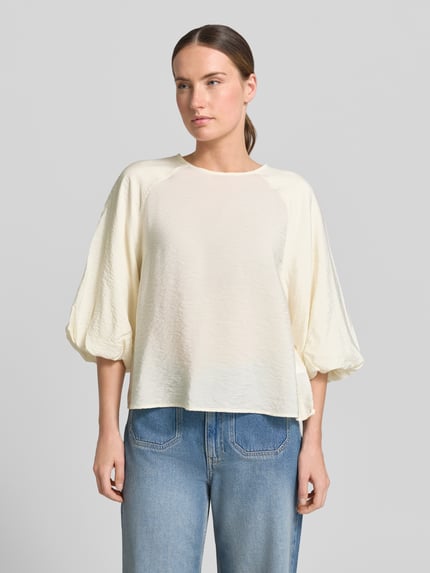Frauenmodel trägt Regular Fit Bluse aus Viskose-Mix mit 3/4-Arm von Christian Berg Woman in Creme, Struktur-Oberfläche, Rundhalsausschnitt, Damen Bluse, Rückenlänge bei Größe 36: 56 cm, Ärmellänge bei Größe 36: 44 cm, Ganzkörperansicht von vorne.