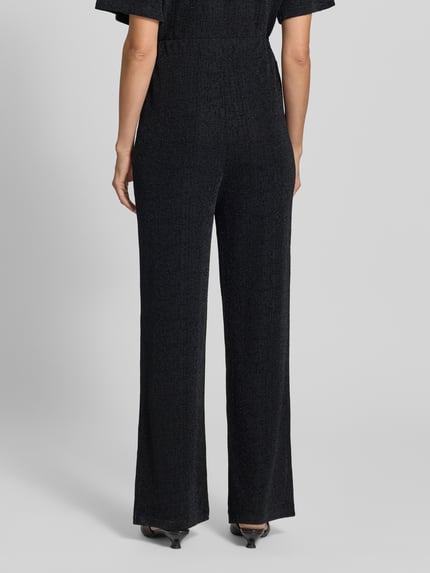 Frauenmodel trägt schwarze, locker fallende Hose mit elastischem Bund, Modell 'NAREEN' von ICHI aus stretchigem Material-Mix, Ganzkörperansicht Rückansicht.