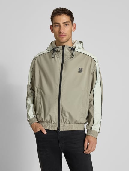 Męski model nosi Regular Fit Jacke mit Kapuze Modell 'BAVO2621' od HUGO w jednolitym kolorze, z logo, długimi rękawami, elastycznym dołem i bocznymi kieszeniami, krój regular fit, całkowity widok z przodu.