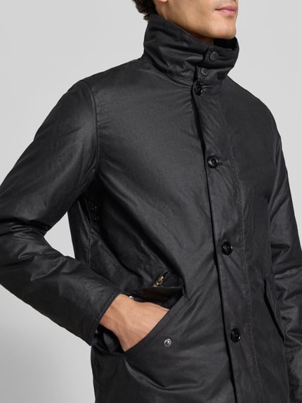 Männermodel trägt Regular Fit Parka aus reiner Baumwolle von Barbour in Schwarz mit mattem Finish, Nahaufnahme Oberkörper.