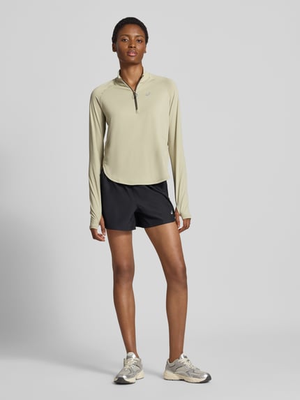 Vrouwenmodel draagt shirt met lange mouwen met schipperskraag Model 'NAGINO' van ASICS TIGER, regular fit, logoprint, Raglanmouwen, ganzich van voren.