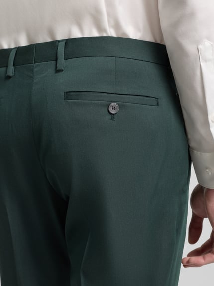 Männermodel trägt Regular Fit Stoffhose aus Satin von MCNEAL in Dunkelgrün mit Gesäßtasche, Detailaufnahme Rückansicht.