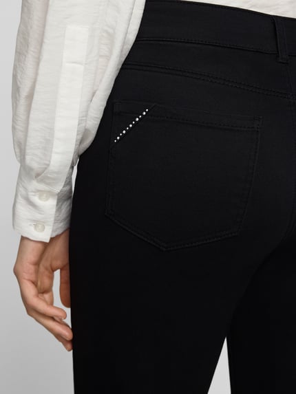 Frauenmodel trägt Straight Fit Stoffhose im 5-Pocket-Design von Christian Berg Woman, schwarzer Stoff, Strasssteinbesatz, Detailaufnahme