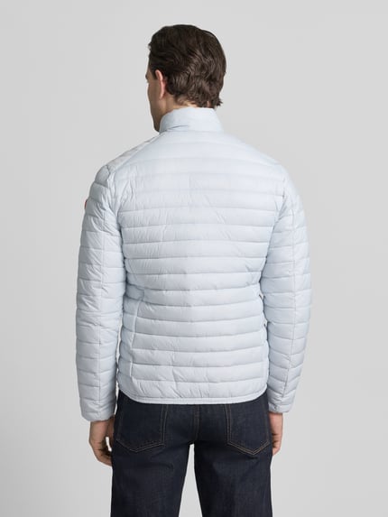 Männermodel trägt hellblaue Steppjacke mit Zweiwegereißverschluss Modell 'Alexander' von SAVE THE DUCK, Ganzkörperansicht Rückansicht, Regular Fit, horizontale Stepp-Optik, Eingrifftaschen, glatte Struktur