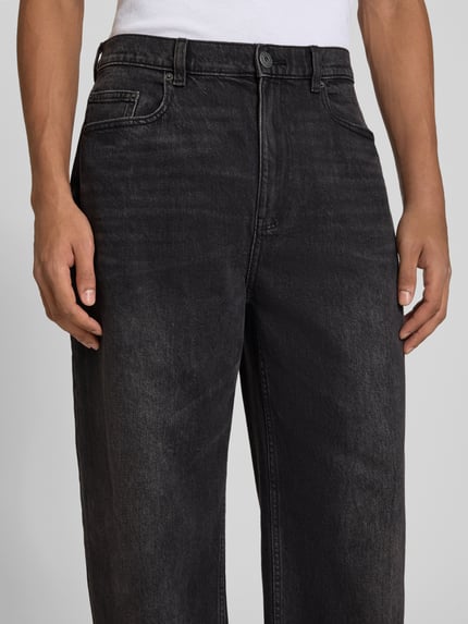 Mężczyzna nosi Baggy Jeans in schwarzer Waschung und klassischem 5-Pocket-Design von REVIEW, Mieszanka bawełny i elastanu, krój baggy, czarny, 5 kieszeni, zapięcie na guzik i zamek błyskawiczny, Szerokość w rozmiarze 32: 42 cm, Długość wewnętrzna nogawki w rozmiarze 32: 76 cm, zbliżenie na górną część spodni z przodu