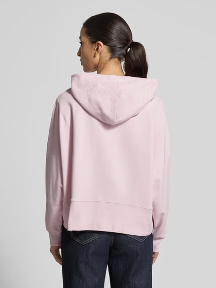Frauenmodel trägt Relaxed Fit Hoodie aus reiner Baumwolle von Marc O'Polo, Optik: Unifarben, Label-Print, Kapuze, Langarm, Rumpfabschluss: Gerippt, Materialverarbeitung: Sweat, Ganzkörperansicht Rückansicht.