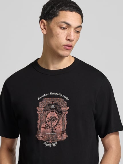 Męski model nosi T-shirt mit Label-Print Modell 'NIAGARA' od JACK & JONES, czarny, bawełna, prosty krój, okrągły dekolt, długość tyłu 67 cm, nadruk z logo, nahaufnahme górnej części ciała.