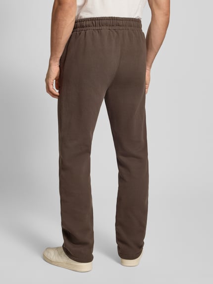 Männermodel trägt Sweathose mit elastischem Bund von Pegador aus Baumwoll-Mix, lockerer Schnitt, Label-Stitching, Rückansicht.