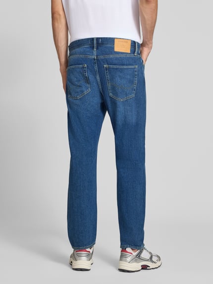 Męski model nosi Straight Fit Jeans aus Baumwoll-Mix Modell 'CHRIS' von JACK & JONES, mieszanka bawełny, 5 kieszeni, Szerokość w rozmiarze 32/32: 41 cm, Długość wewnętrzna nogawki: 72 cm, widok całej sylwetki z tyłu.