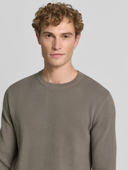 Männermodel trägt Slim Fit Strickpullover Baumwoll-Mix von Lindbergh, gerippte Optik, Rundhalsausschnitt, Nahaufnahme Oberkörper.