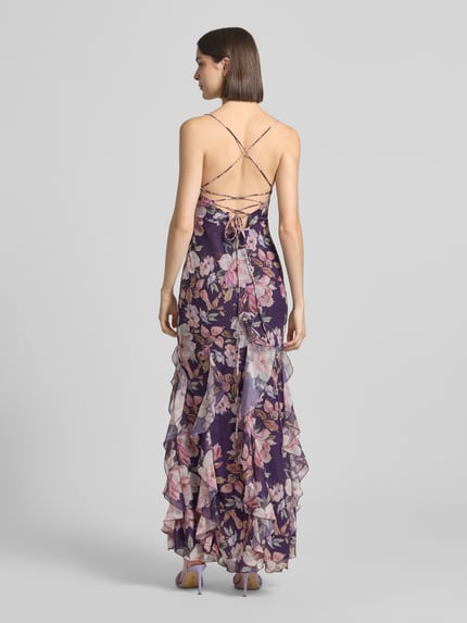 Frauenmodel trägt Slim Fit Abendkleid mit Rüschenbesatz von ADLYSH, floraler Allover-Print, Schnürverschluss, Spaghettiträger, Rückenlänge bei Größe S 132 cm, Brustweite bei Größe S 28 cm, Ganzkörperansicht Rückansicht.