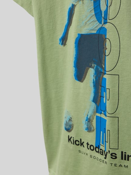 Mädchen trägt Regular Fit T-Shirt aus reiner Baumwolle von s.Oliver RED LABEL, Optik: Unifarben mit Motiv-Print, Nahaufnahme Oberkörper.
