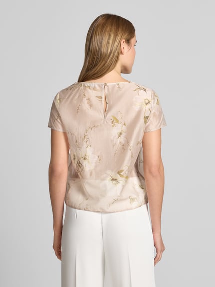 Modelka nosi Blusenshirt mit Rundhalsausschnitt und abgerundetem Saum von Rinascimento z lyocellu, krój loose fit, pastelowe kolory, kwiatowy wzór, zaokrąglony dół, długość tyłu w rozmiarze S: 59 cm, pełny widok od tyłu