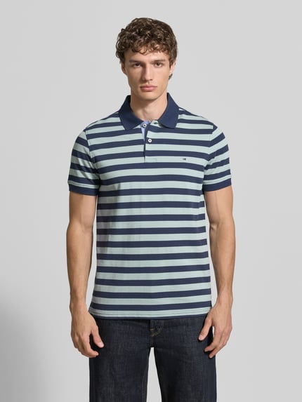Männermodel trägt Modern Fit Poloshirt mit Logo-Stitching von Christian Berg Men, Reine Baumwolle, Polokragen, Knopfleiste, Ganzkörperansicht von vorne.