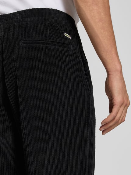 Männermodel trägt Regular Fit Cordhemd mit Logo-Patch von LACOSTE in Schwarz mit Struktur, Detailaufnahme Nahaufnahme Hüfte.