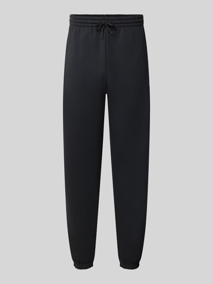Produktfoto, Regular Fit Sweatpants aus Baumwoll-Mix mit Label-Stitching von New Balance, Schwarz, elastischer Bund mit Tunnelzug, glatte Struktur