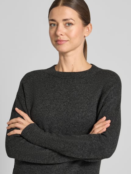 Kobiece model prezentuje Strickpullover mit überschnittenen Schultern od Christian Berg Woman, luźny fason, dzianina, okrągły dekolt, prążkowane wykończenia, szara faktura, długość tyłu 60 cm, długość rękawa 58 cm, zbliżenie na górną część ciała