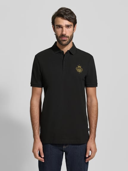 Männermodel trägt Regular Fit Poloshirt aus reiner Baumwolle Modell 'QIANG' van BOSS, uni zwart, label print, piqué, Ganzkörperansicht von vorne.