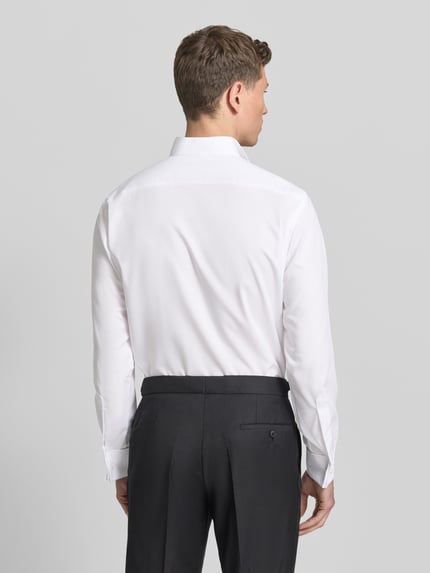 Männermodel trägt Modern Fit Business-Hemd mit verdeckter Knopfleiste von OLYMP in Weiß, reine Baumwolle, Ganzkörperansicht Rückansicht.