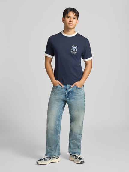 Männermodel trägt blaue Loose Fit Jeans aus reiner Baumwolle Modell 'G-Star Arc 3D Loose' von G-Star RAW, Herren Weite Hose, Ganzkörperansicht von vorne.