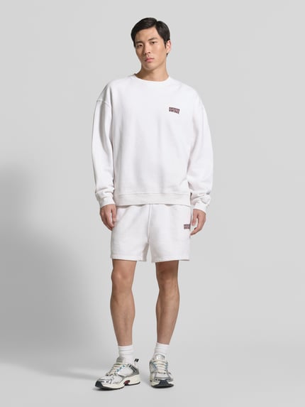 Männermodel trägt Shorts mit Logo Modell 'PLIZZY' von American Vintage aus Reine Baumwolle, Relaxed-Fit, Logo, Tunnelzug, Ganzkörperansicht von vorne.