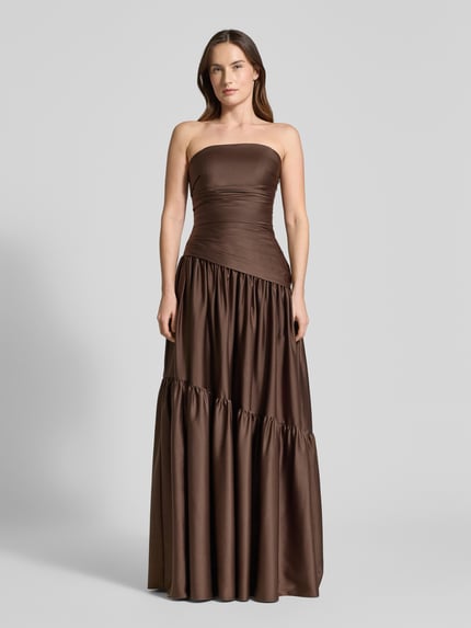 Frauenmodel trägt Regular Fit Abendkleid in Falten-Optik von Luxuar, brauner Satin, A-Linie, schulterfrei, tailliert, Ganzkörperansicht von vorne.