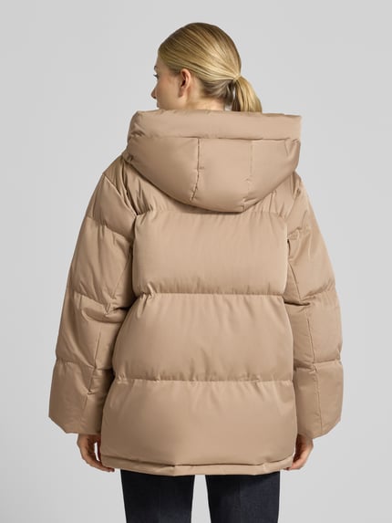 Vrouwenmodel draagt Pufferjacke mit Kapuze Modell 'Hilena' van OPUS, look: effen, lang, ritssluiting, mouwvorm: lange mouw, mouwboord: geribd, rompzoom: recht, steekzakken aan de zijkant, Ganzkörperansicht Rückansicht.