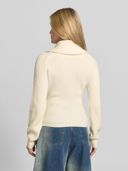 Frauenmodel trägt Pullover aus Wolle mit Troyerkragen von Anine Bing, unifarben, Rippstrick, Struktur, Ganzkörperansicht Rückansicht.