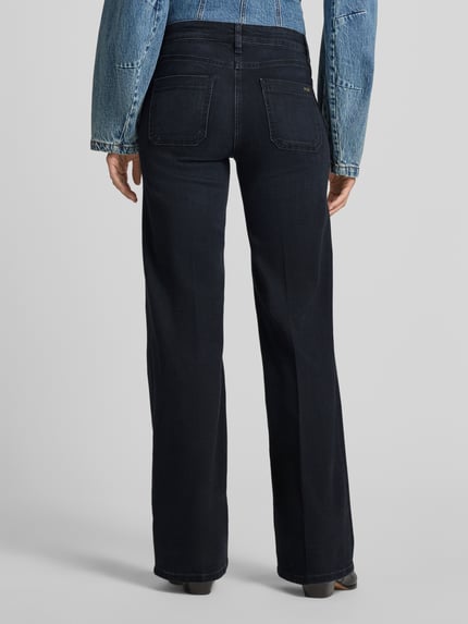 Frauenmodel trägt dunkelblaue Bootcut-Jeans aus Baumwoll-Modal-Mix Modell 'AMARA' von CAMBIO, glatte Textur, Ganzkörperansicht Rückansicht, Damen Bootcut-Jeans von CAMBIO.