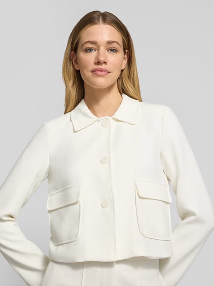 Vrouwenmodel draagt blazer met klepzakken model 'RITA' van GUIDO MARIA KRETSCHMER WOMAN, materiaalmix met viscose, recht model, kentkraag, knoopsluiting, voorkant detailopname van het bovenlichaam.