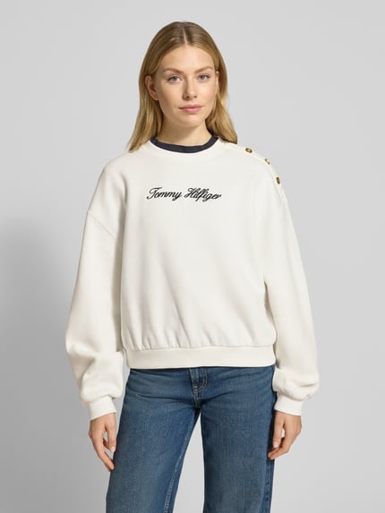 Vrouwenmodel draagt Relaxed Fit Sweatshirt uit katoenmix van Tommy Hilfiger in effen wit met label stitching, geribde boorden, voorkant bovenlichaam close-up.
