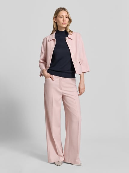 Frauenmodel trägt schwarzen Slim Fit Pullunder aus reiner Schurwolle Modell 'FIPINI' von BOSS, Damen Pullunder, Ganzkörperansicht von vorne.