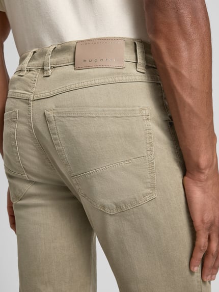 Männermodel trägt Regular Fit Jeans mit Eingrifftaschen von bugatti in Beige, Baumwoll-Mix mit Stretch, Nahaufnahme Rückansicht.