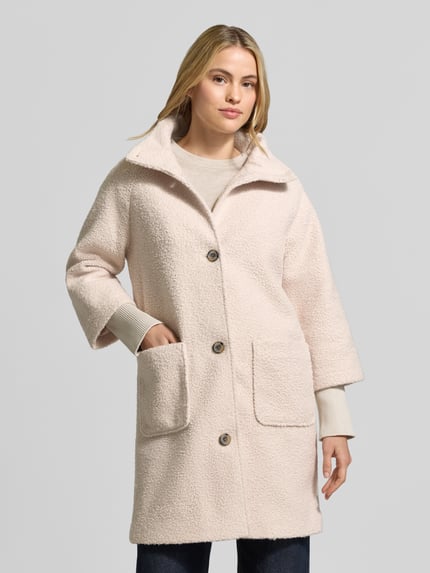 Frauenmodel trägt Teddymantel mit hohem Stehkragen von TOM TAILOR in cremefarben, Longline, aus Polyester, aufgesetzte Taschen, Ganzkörperansicht von vorne.