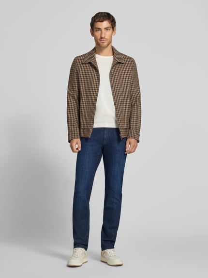 Männermodel trägt Modern Fit Jeans aus Baumwoll-Mix Modell 'Chuck' von Brax in Denim-Optik, 5-Pocket, Vorderansicht, Ganzkörperansicht von vorne.