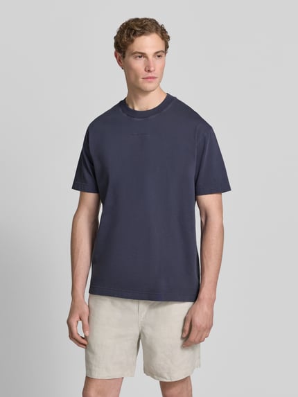 Männermodel trägt Relaxed Fit T-Shirt aus reiner Baumwolle von Marc O'Polo in Optik: Unifarben mit Label-Schriftzug, Ganzkörperansicht von vorne.