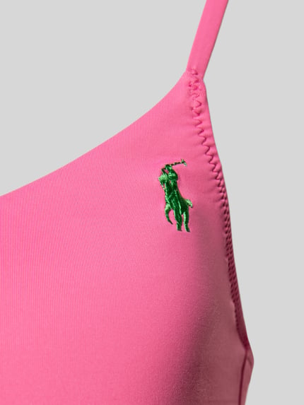 Vrouwenmodel draagt Bikini-Oberteil mit Logo-Stitching van Polo Ralph Lauren in effen kleuren, met verstelbare spaghettibandjes, gevoerd, uitneembaar, zonder beugel, zonder sluiting, applicatie met gestikt logo, hartvormige hals. Detailopname.