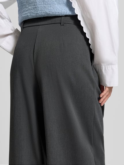Frauenmodel trägt dunkelgraue Weite Hose mit Viskose-Anteil Modell 'STELLA' von VERO MODA, feine Struktur, Nahaufnahme Rückansicht. Damen Weite Hose von VERO MODA.