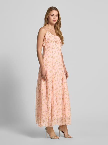 Frauenmodel trägt Abendkleid mit Spaghettiträgern Modell 'SOIREE' von YAS aus rosafarbenem Chiffon mit Volant und floralem Muster, Maxikleid, Taillierter Schnitt, Rückenlänge 131 cm, Brustweite 127 cm, Ganzkörperansicht von vorne.