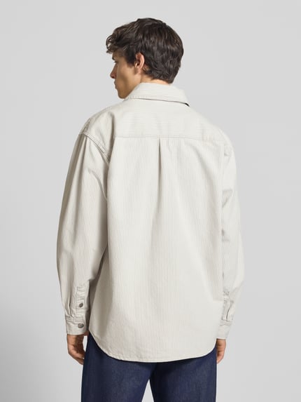 Männermodel trägt Regular Fit Hemdjacke mit Zweiwege-Reißverschluss van Carhartt Work In Progress, katoen, borstzakken, labeldetail, rugaanzicht, ganzkörperansicht rückansicht.