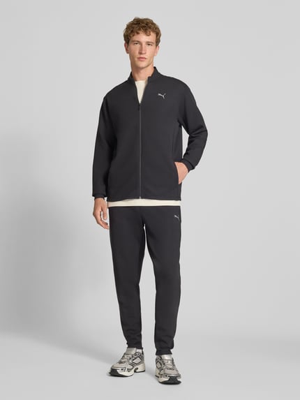Männermodel trägt Sweatjacke mit Stehkragen und Reißverschluss Modell 'CLOUDSPUN' von PUMA PERFORMANCE, Material-Mix, Ganzkörperansicht von vorne.
