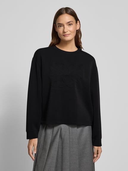 Modelka kobieca nosi Regular Fit Sweatshirt aus Modal-Mix od s.Oliver RED LABEL, czarny, z logo, długi rękaw, okrągły dekolt, widok z przodu, ujęcie do pasa.