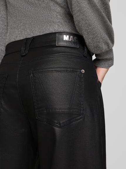 Frauenmodel trägt Loose Fit Barrel Jeans aus Modal-Mix Modell 'DANNI 2.3' von MAC in Schwarz, glatte strukturierte Oberfläche, Nahaufnahme Rückansicht, Damen Barrel Jeans von MAC.